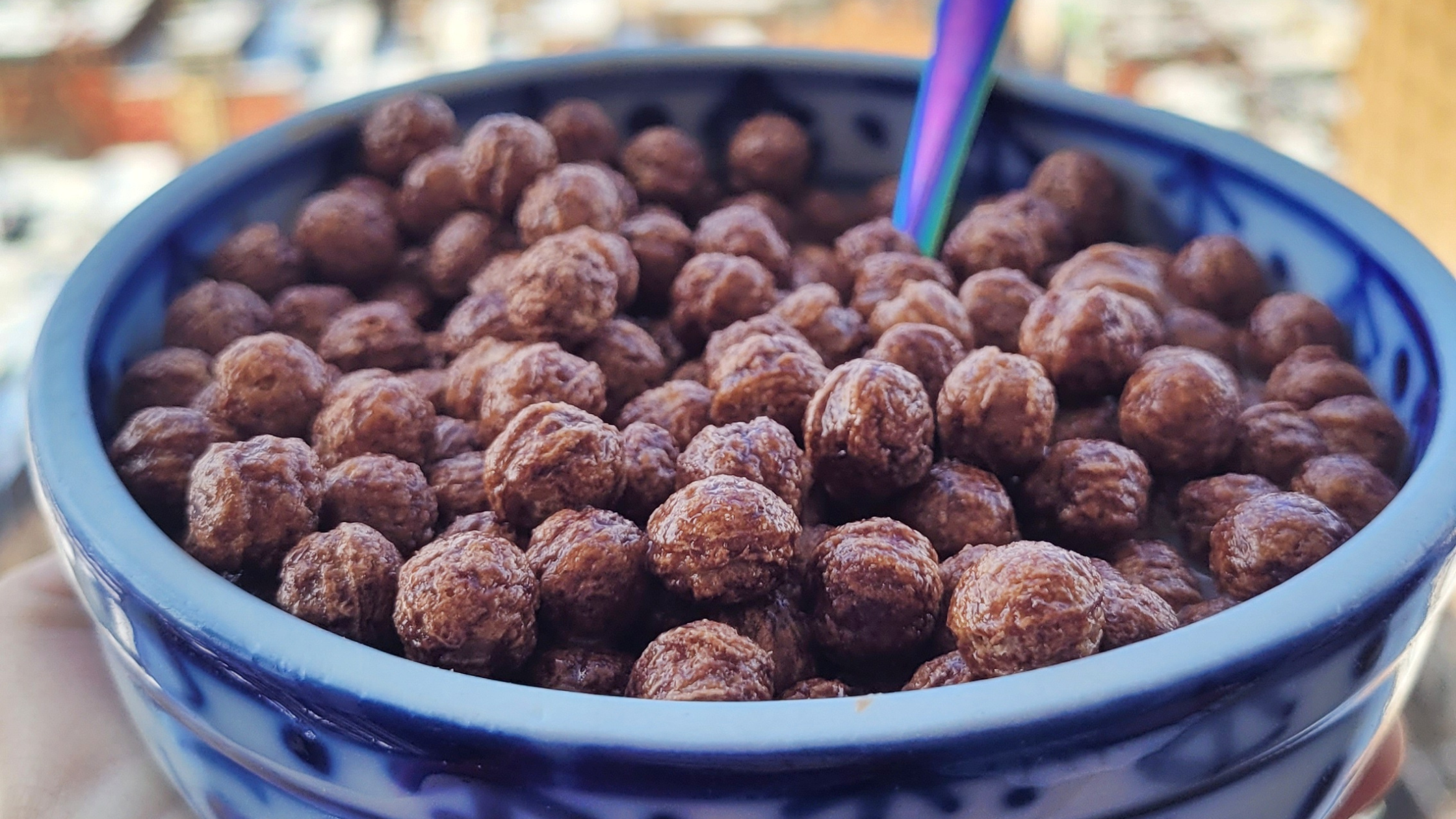 Coco Puffs in a blue bowl in front of a Philadelphia skyline.